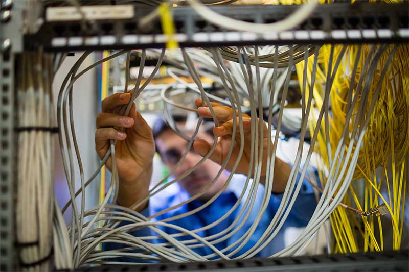 Picture of engineer cabling in a network cabinet